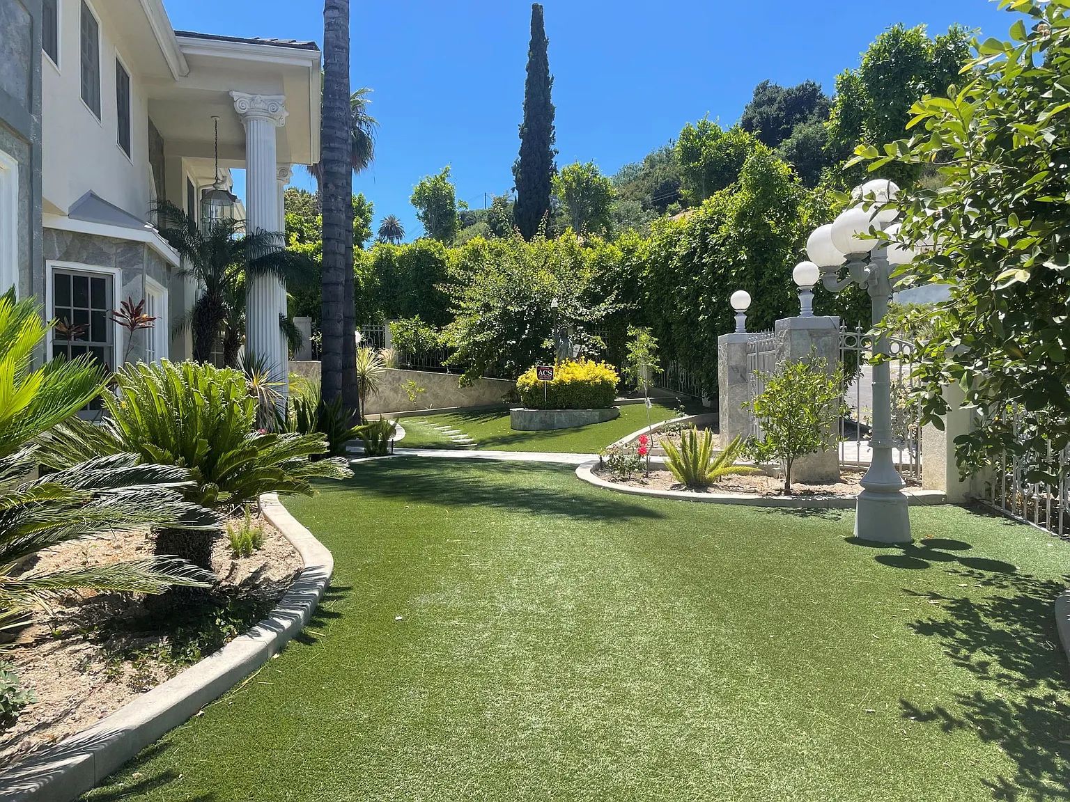 The front lawn and gardens of the Next Phase residence in daylight