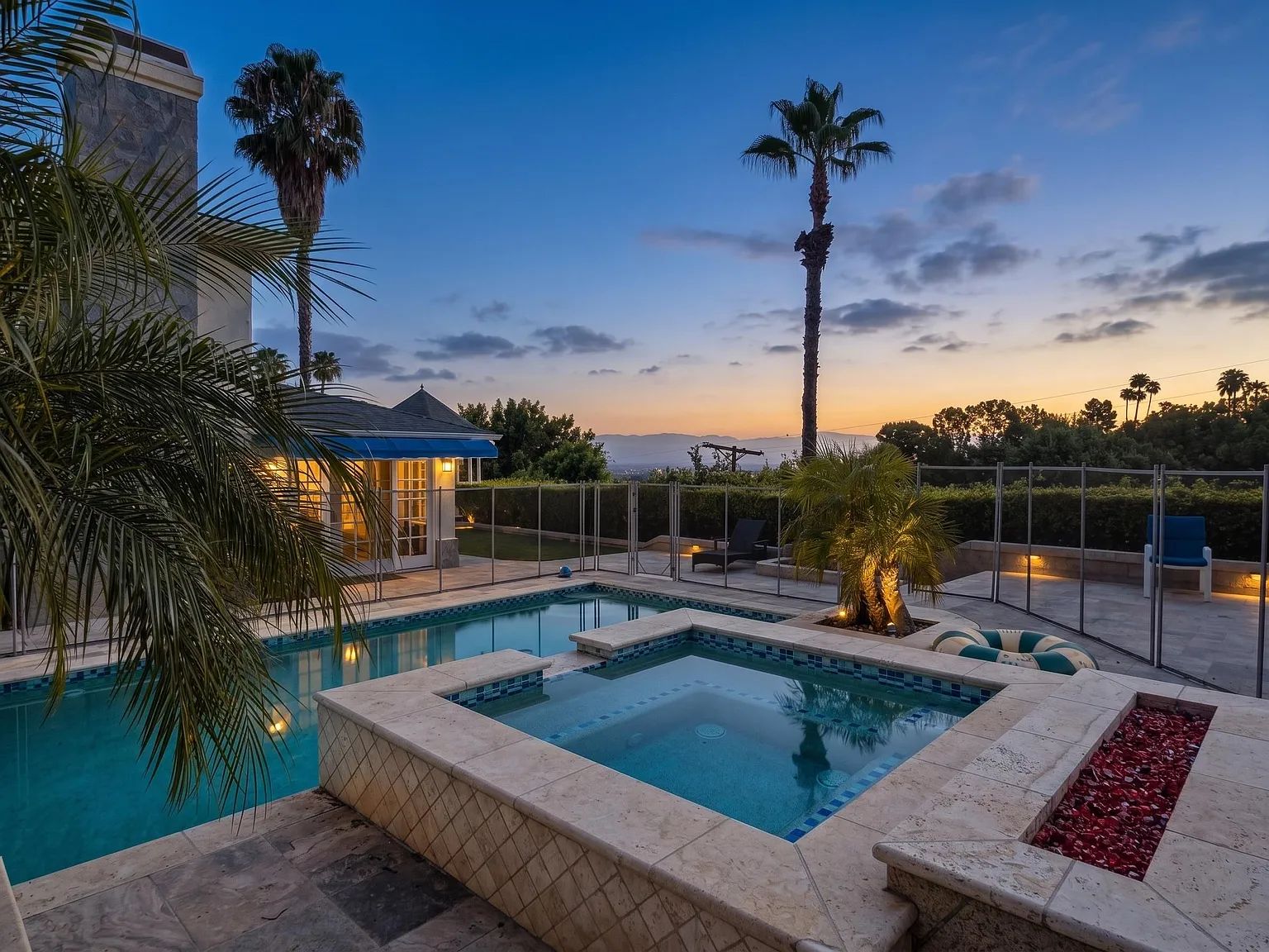 The pool and residence glowing at dusk