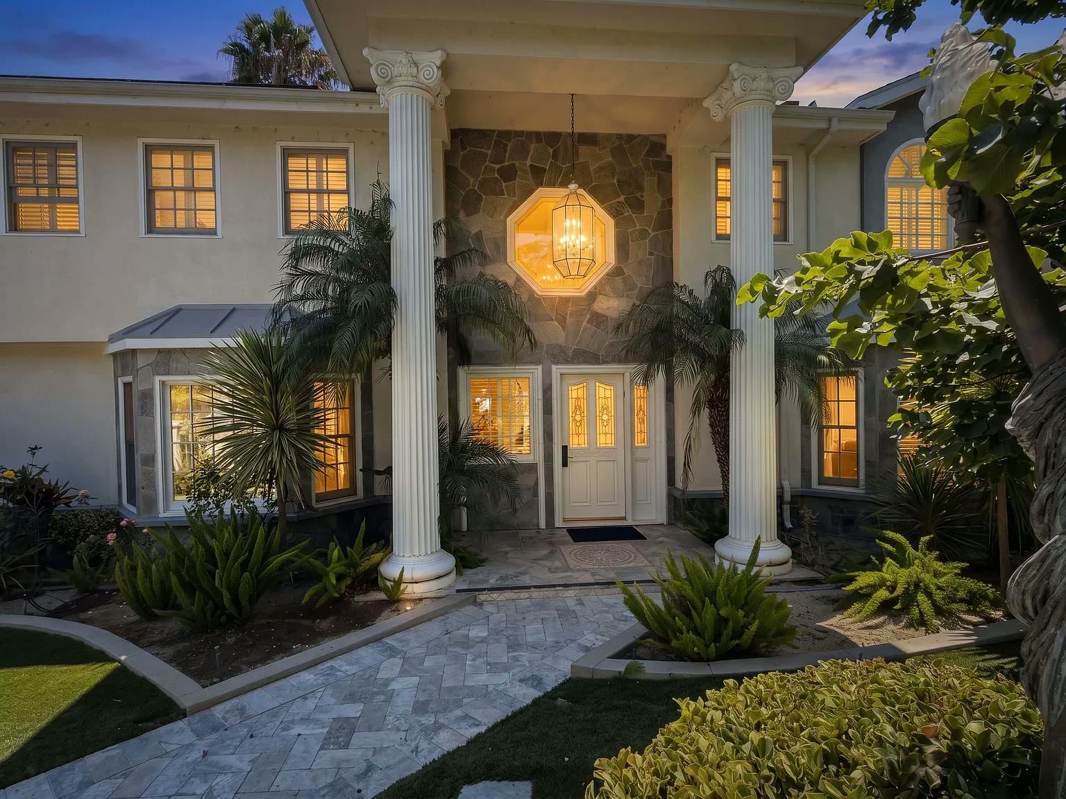 Front entrance of the Next Phase residence with garden lighting at dusk