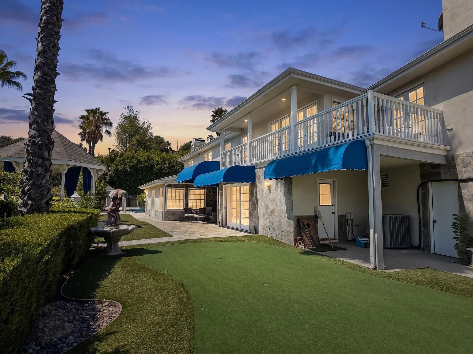 The backyard with gazebo and lawn at sunset